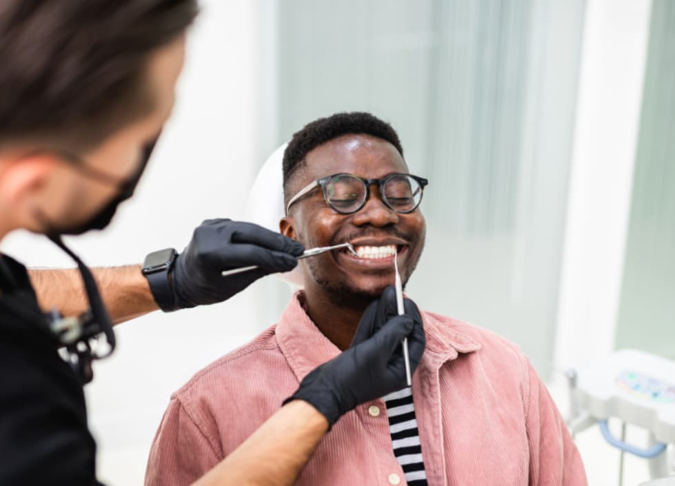 Senior Restorative Dental hygienist examining a smiling patient during a routine dental cleaning at Ridgetop Dental.